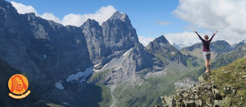 person standing in the mountains with their hands in the air